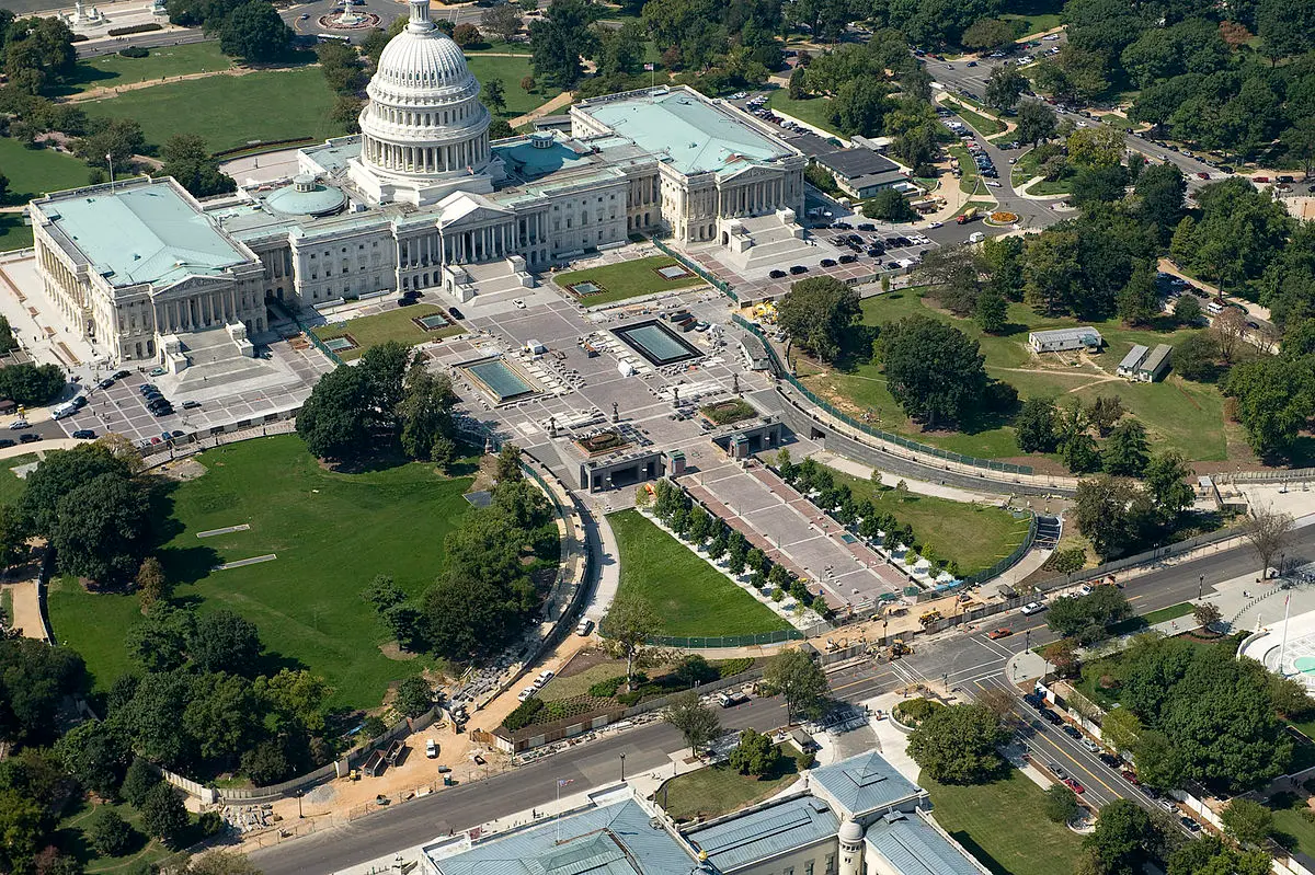 Aerial view of the United States Capitol in Washington, DC, showcasing the dome, plaza fountains, and landscaped grounds.
